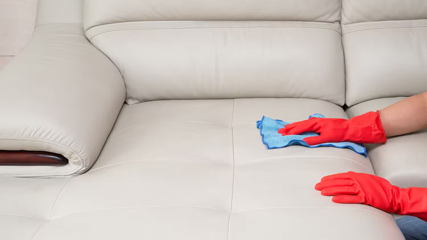 pessoa passando pano em sofá