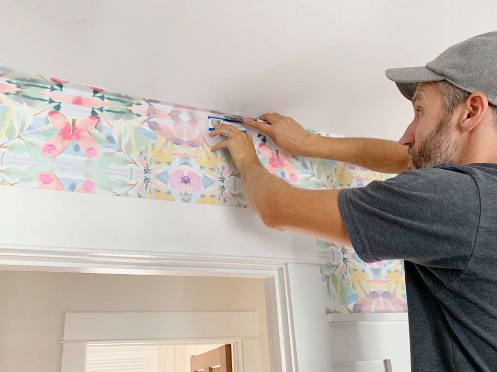 homem aplicando papel de parede